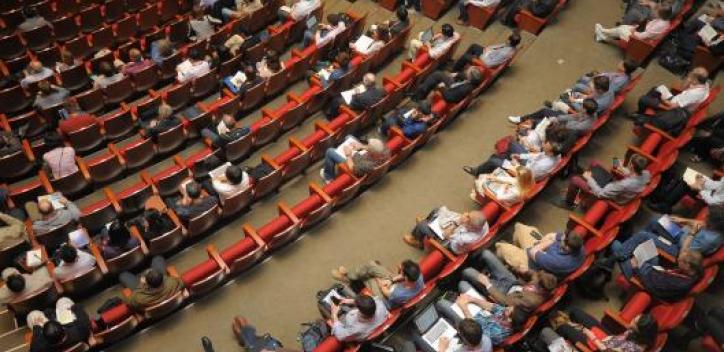 Aerial view of peope sitting in rows of seats in an arena.