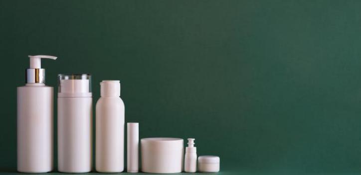 Cosmetic and beauty bottles in white with green background