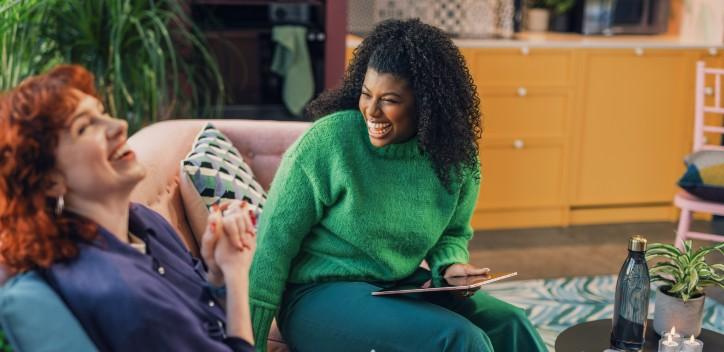 image of friends sitting in a living room laughing