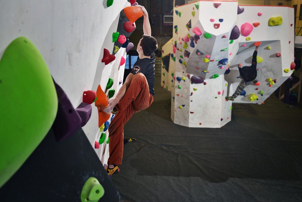 Two climbers doing indoor wall climbing