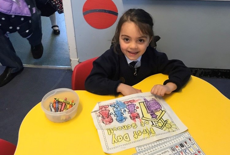 young girl drawing pictures at a table