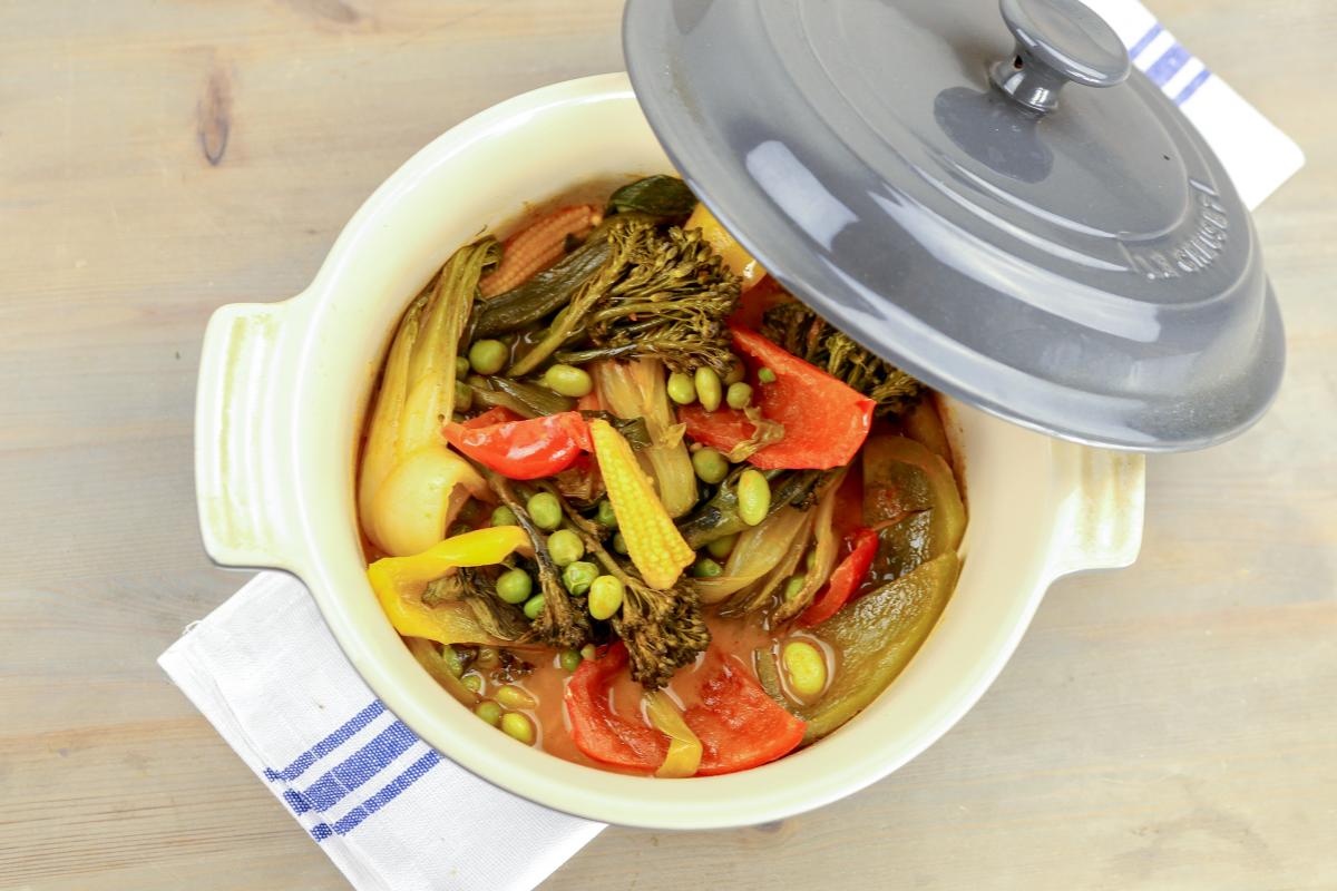 vegan Baked Thai-spiced vegetables in a round pot with lid open to the right side