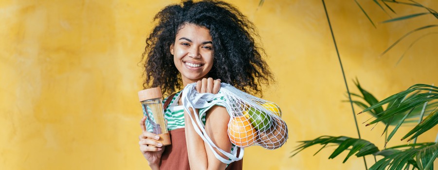 person holding a grocery bag with vegetables