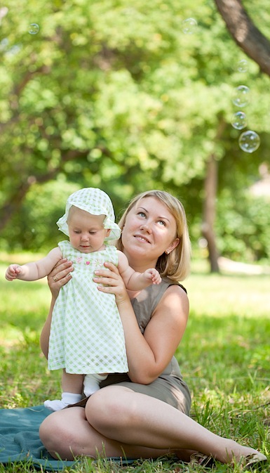 adult with baby and bubbles outside