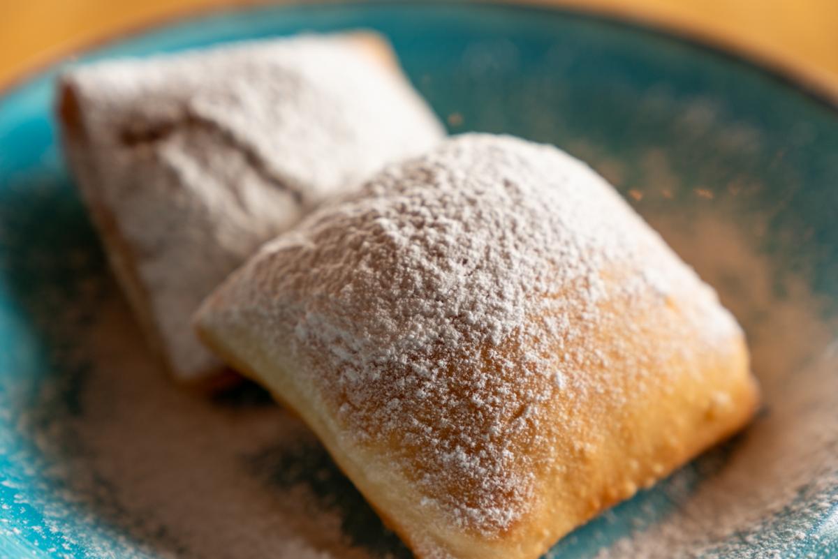 Beignet dessert fried dough and topped with powdered sugar. 