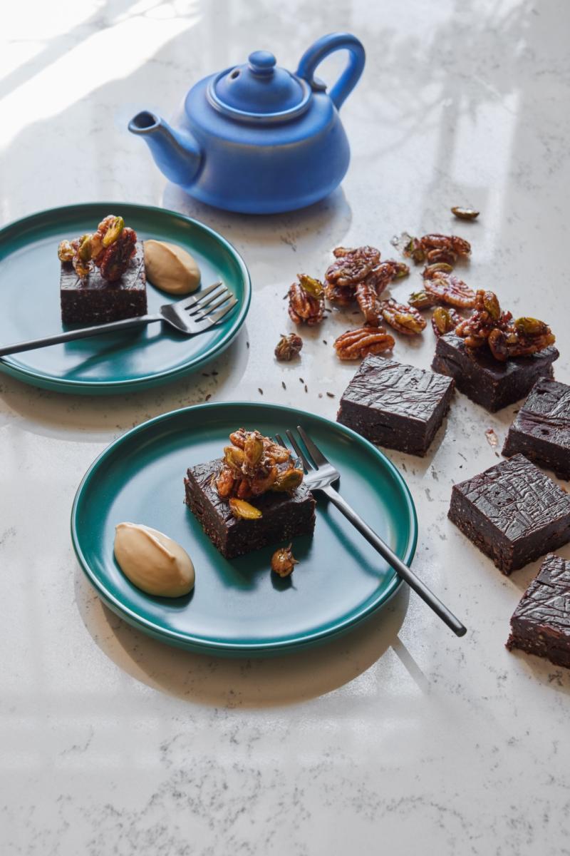 Black bean brownies with salted caramel pecon crunch served at a table with a pot of tea