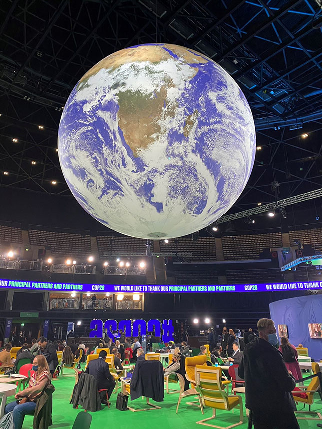 A photo of the COP26 blue zone with a large illuminated globe in the centre