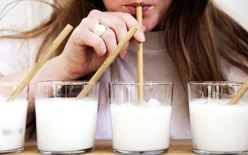 Person drinking from bamboo straws