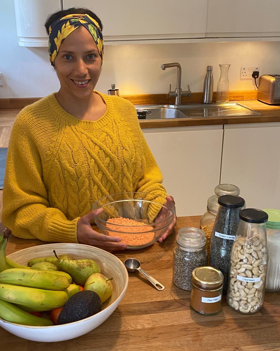 Person in a kitchen using reusable jars to store food