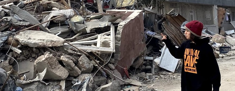 Photograph of Doga working in Turkey next to a collapsed building