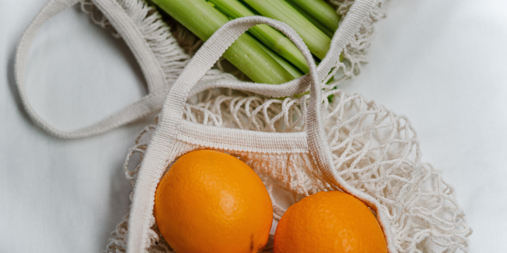 orange and celery in a net bag