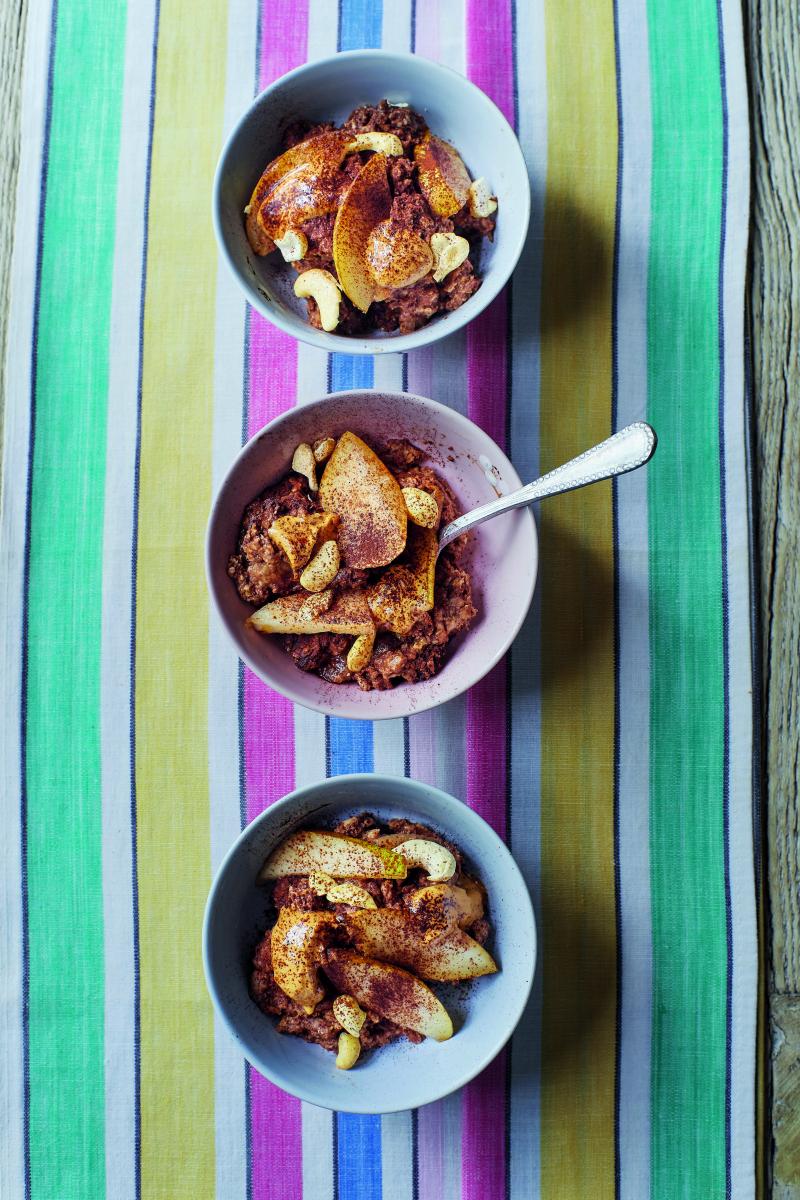 Three bowls of baked oats in vertical order against a colourful striped background