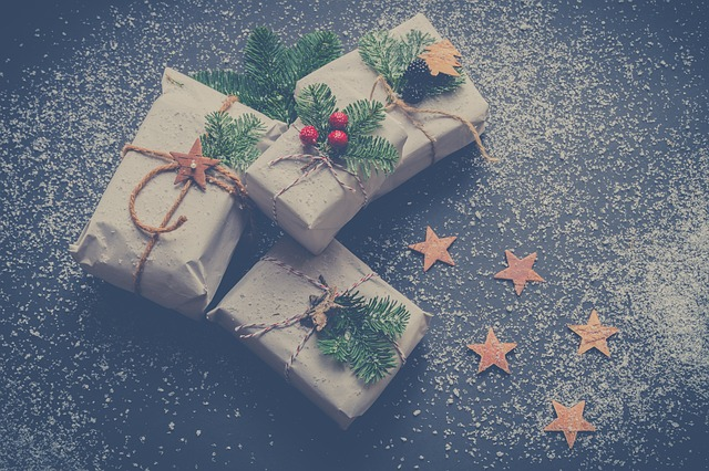 Homemade Christmas gifts, wrapped up in brown paper with sprigs of greenery and stars
