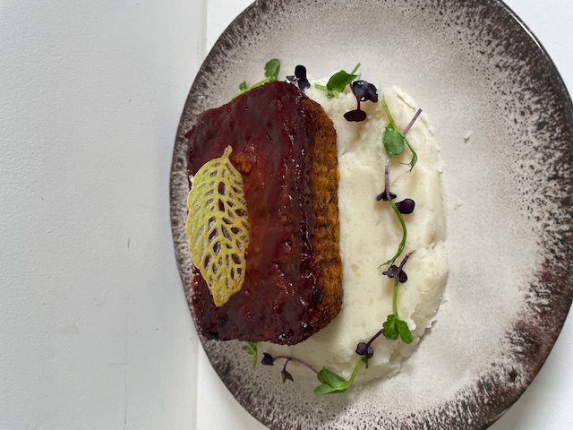 Vegan meatless meatloaf presented with mash potato and herbs