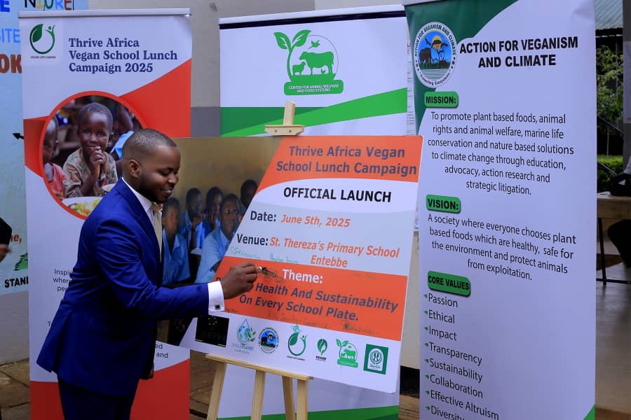 Kiggundu Ronald Reagan signing official launch of Thrive Africa Vegan School Lunch Campaign