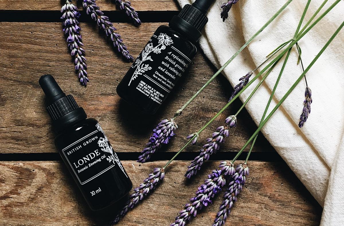 Londe bottles against a wooden background with a cream canvas bag and lavender 