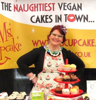 Ms Cupcake with a stand of delicious vegan cupcakes