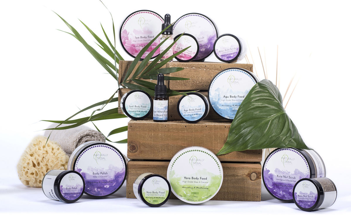 Product shot of naturally Tribal skincare range on wooden crates with plants and a sponge 