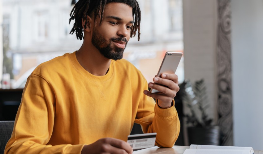Person holding bank card whilst online shopping