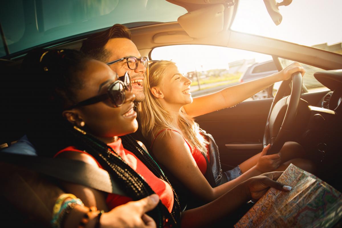 Three people smiling in a car