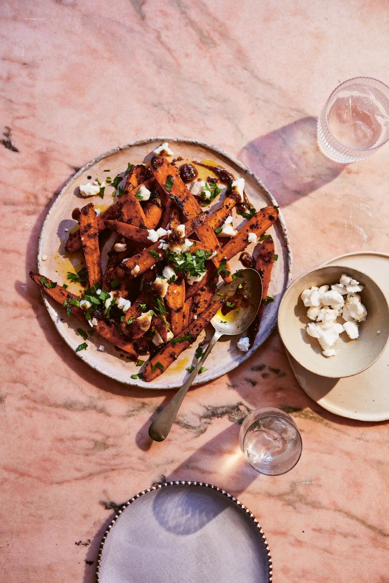 photograph of sweet and sticky jerk roasted carrots with vegan feta on a plate