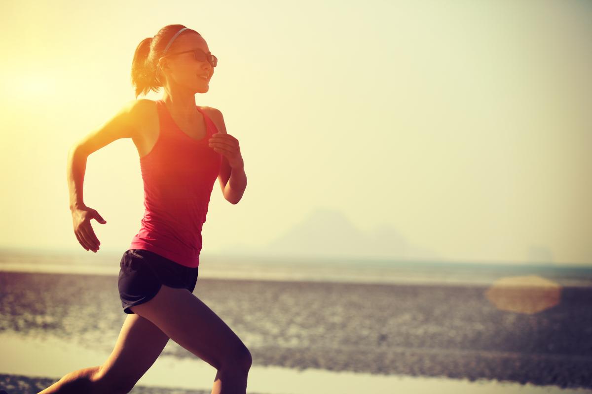 Woman in red top running in sunset