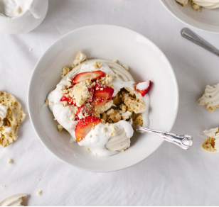 photograph meringue nests in a bowl with strawberries