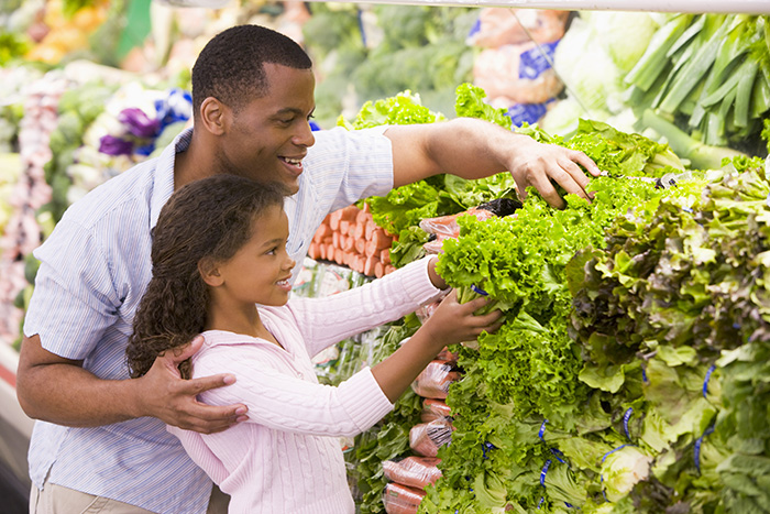 Father with daughter looking at fruit and veg