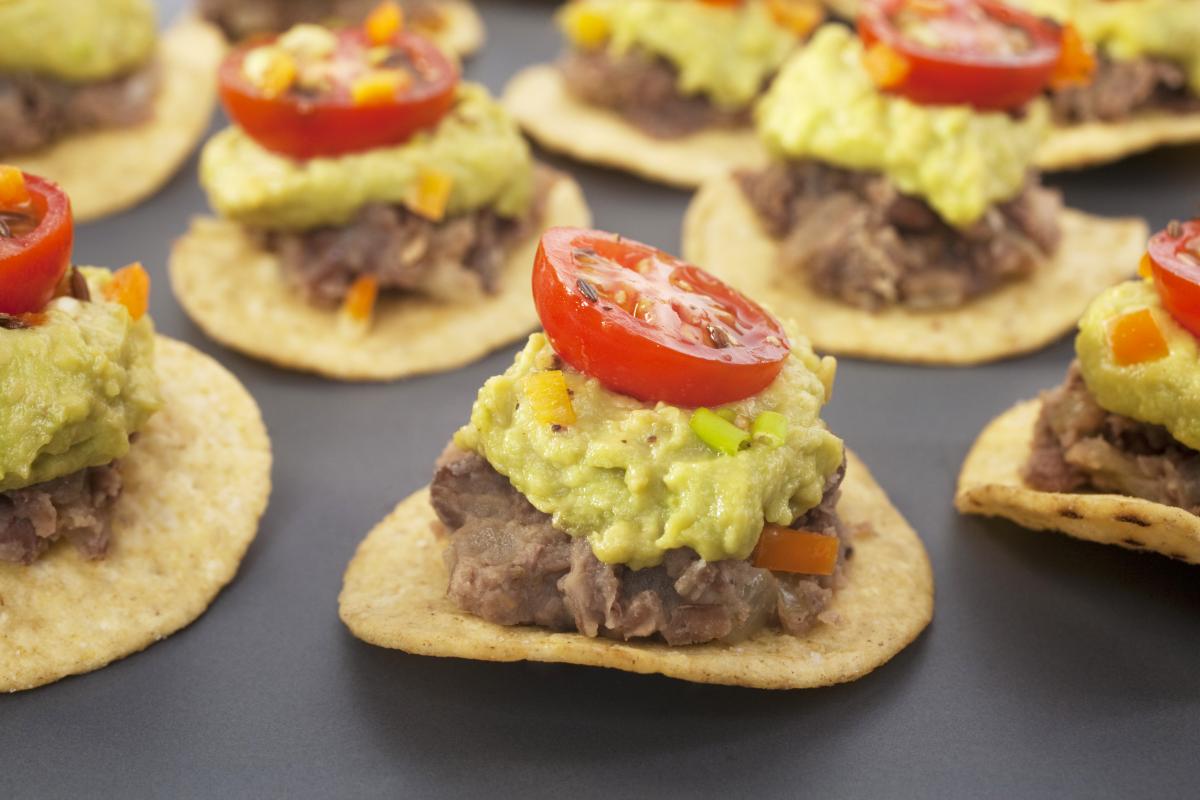 tortilla chips topped with beans and guacamole - vegan mexican food 