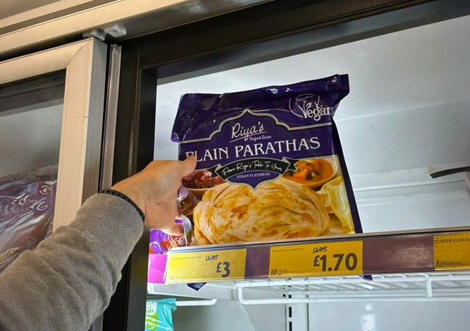 Trusted vegan certification logo on a food product in a supermarket aisle. | Vegan mark on Riya's Original product.