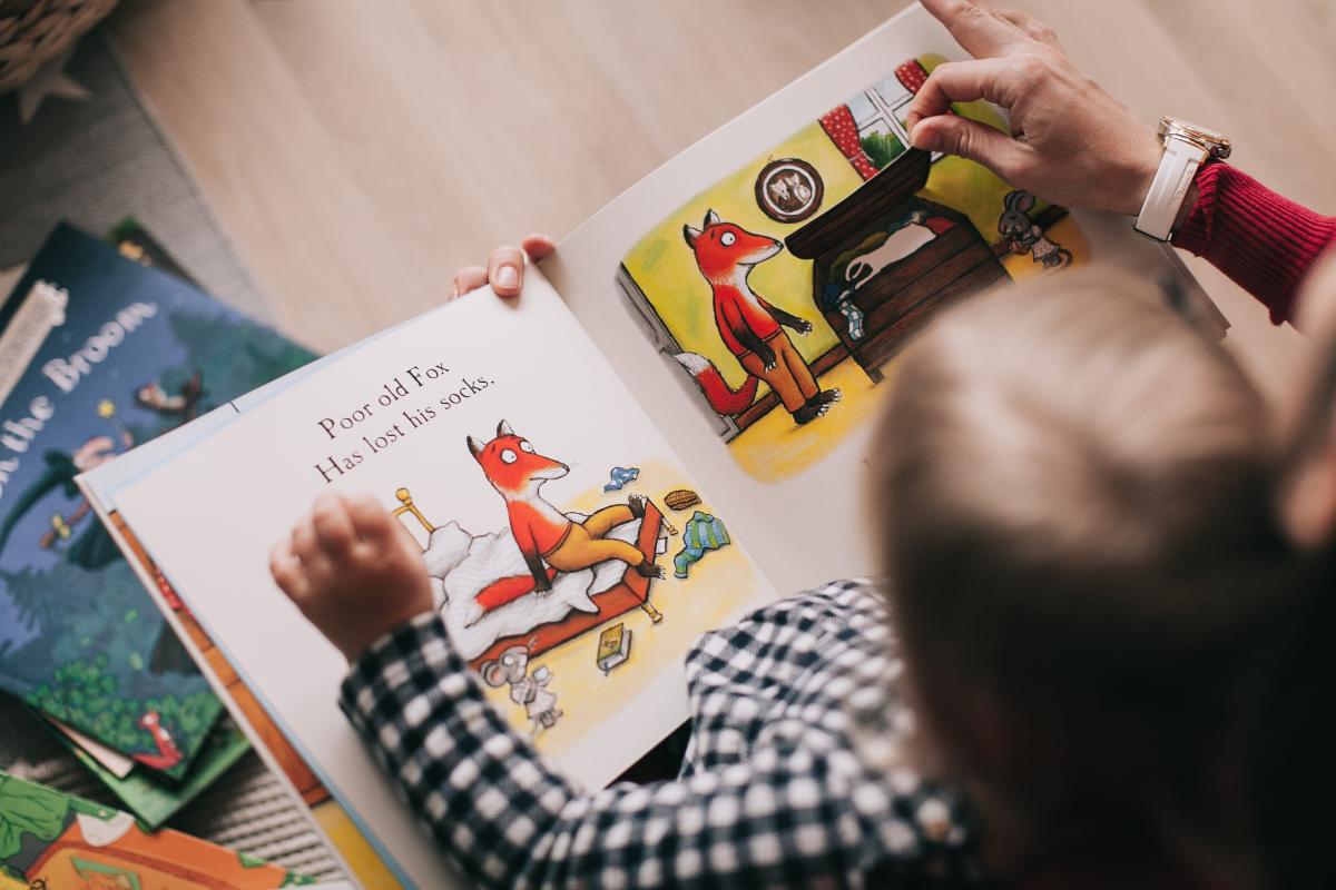 child reading a story book about a fox