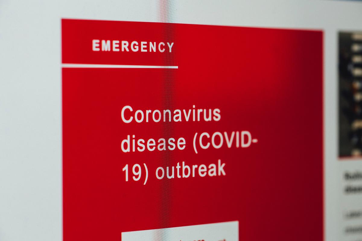 computer screen with red warning sign of a pandemic