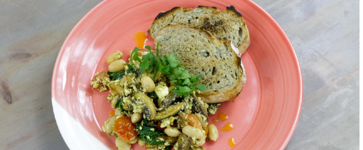 tofu and chesnut mushroom scramble served on a pink plate photograph