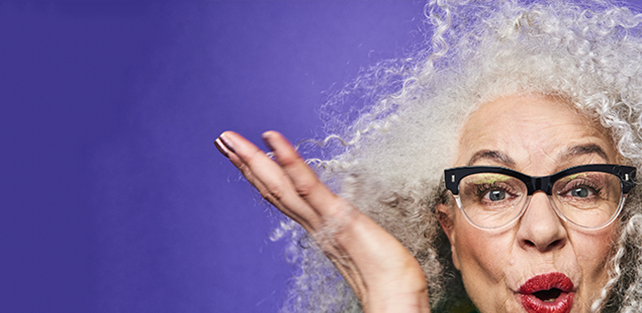 happy older lady with curly grey hair on purple background 
