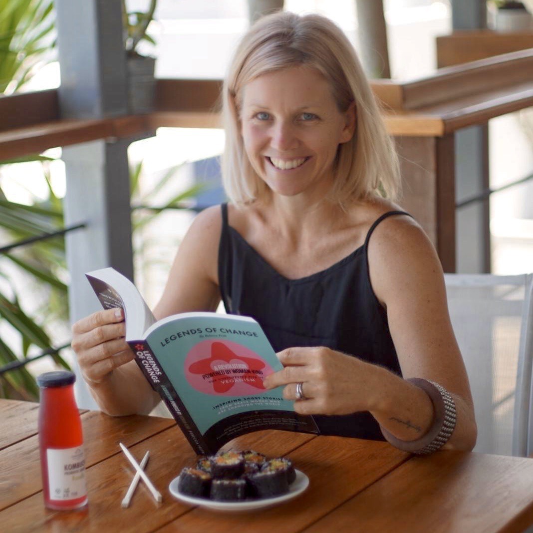 Rebecca Frith sitting at a table with her book