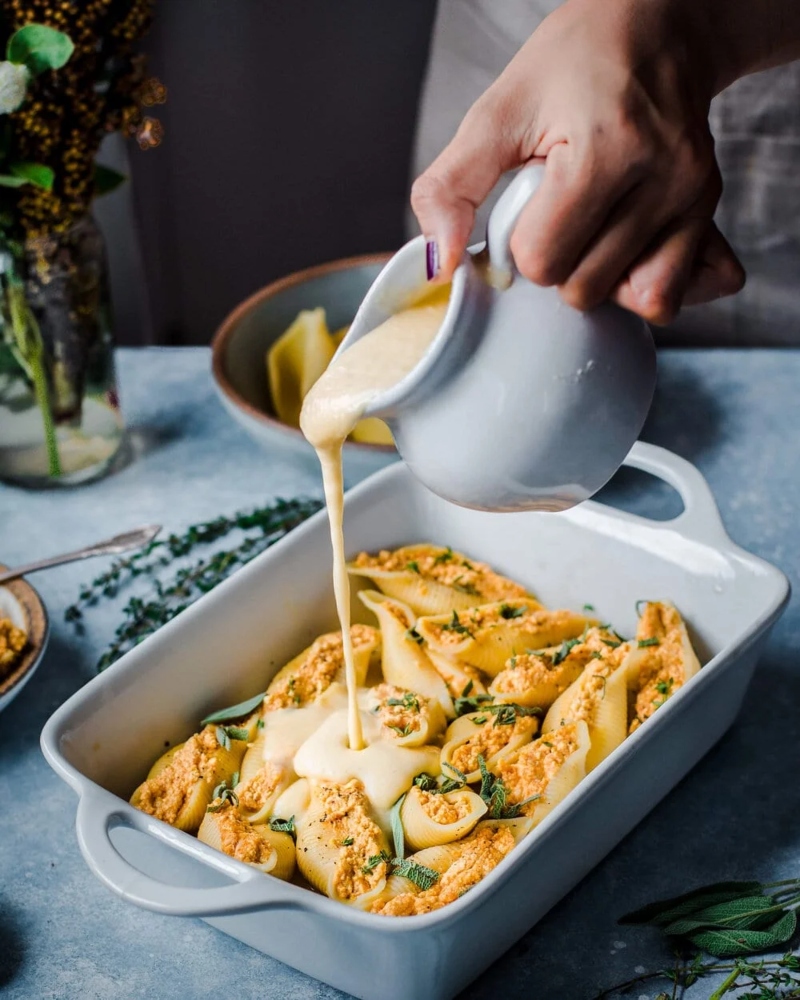 Photograph of vegan pumpkin ricotta stuffed shells being served in a dish